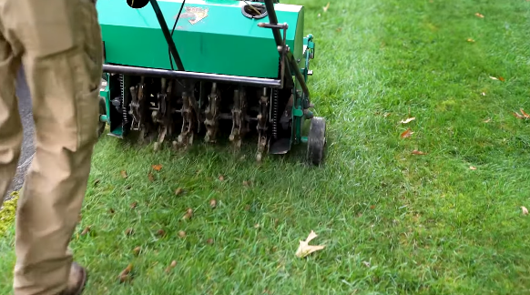 Core aeration machine pulling soil plugs to relieve compaction and thicken turf in Dalton GA
